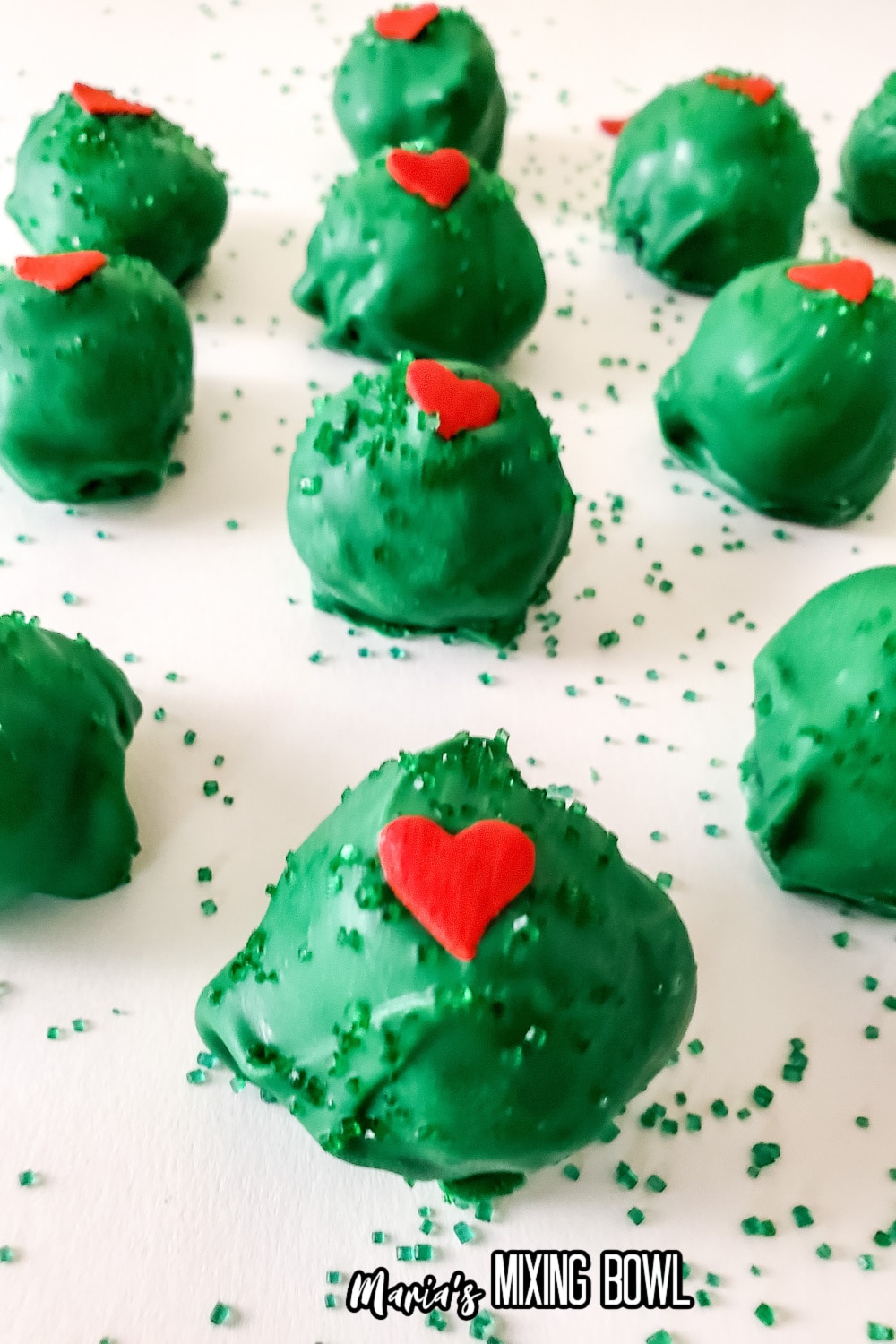 grinch truffles on a parchment lined baking sheets