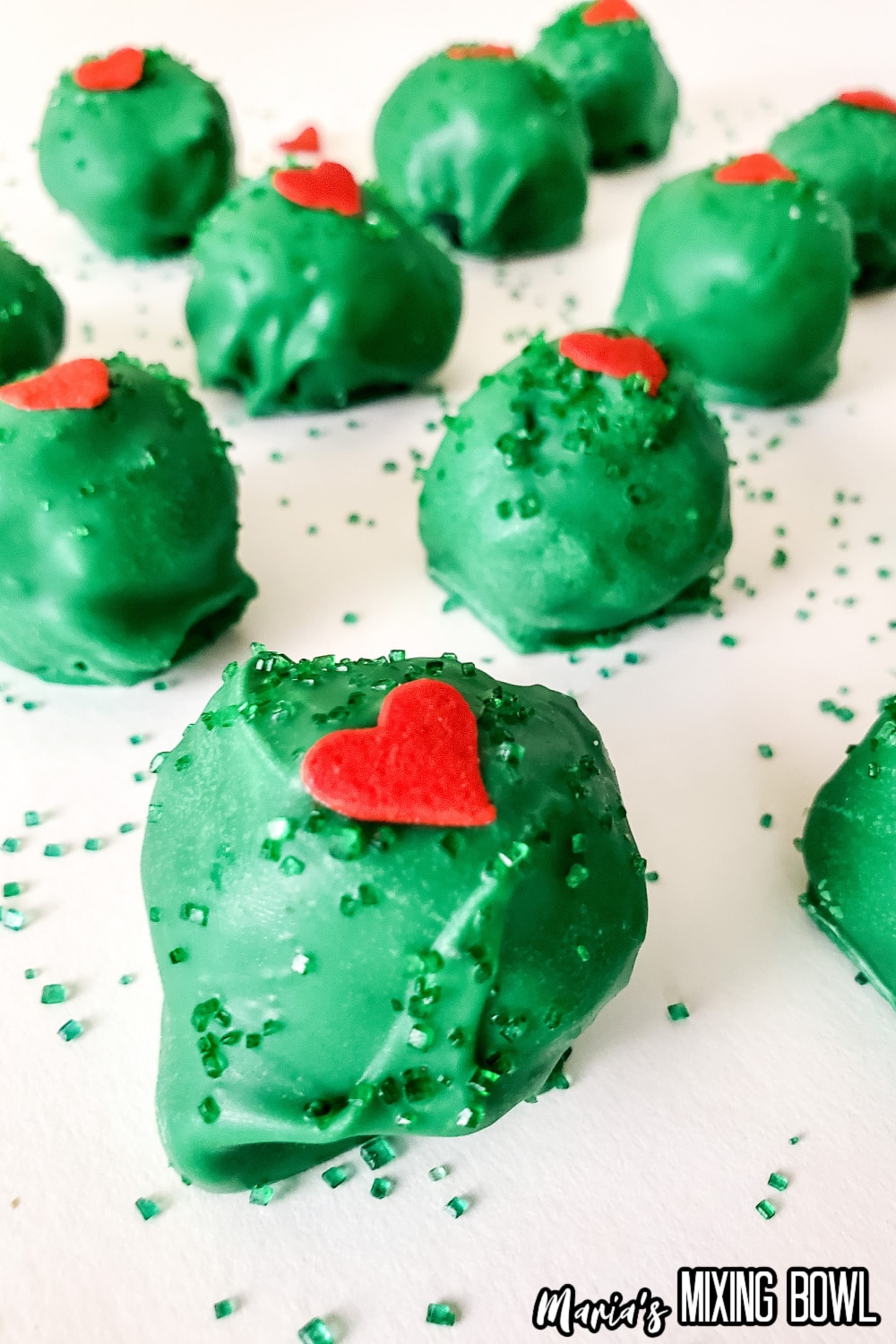 grinch truffles on a parchment lined baking sheets