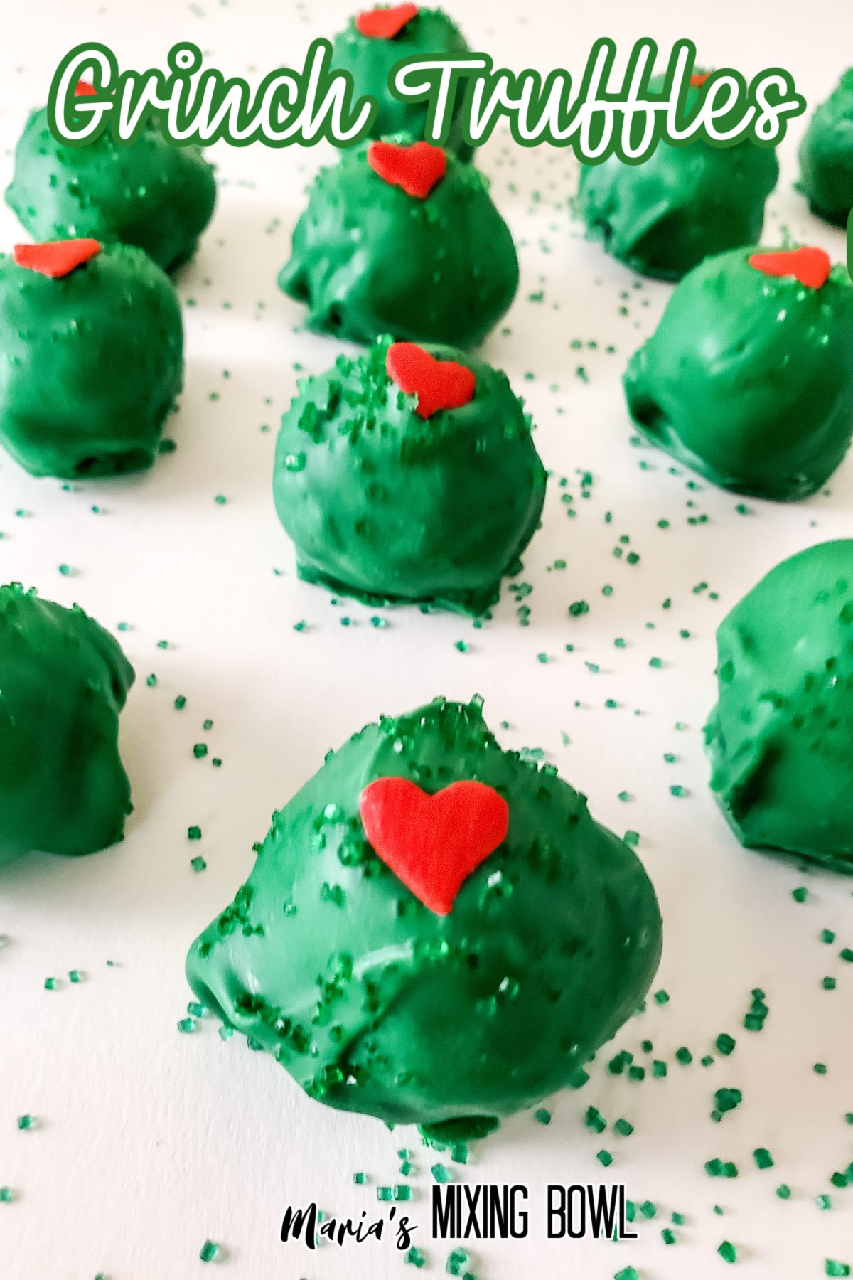 grinch truffles on a parchment lined baking sheets with the name in text for pinterest