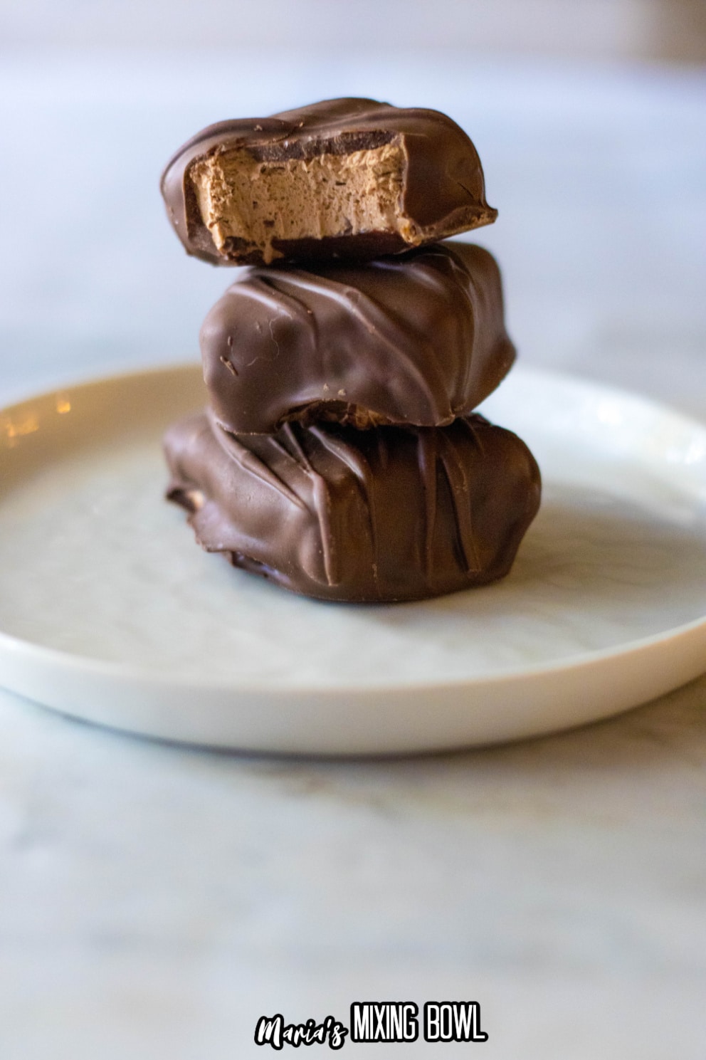 3 pieces of homemade 3 musketeers stacked on a white plate