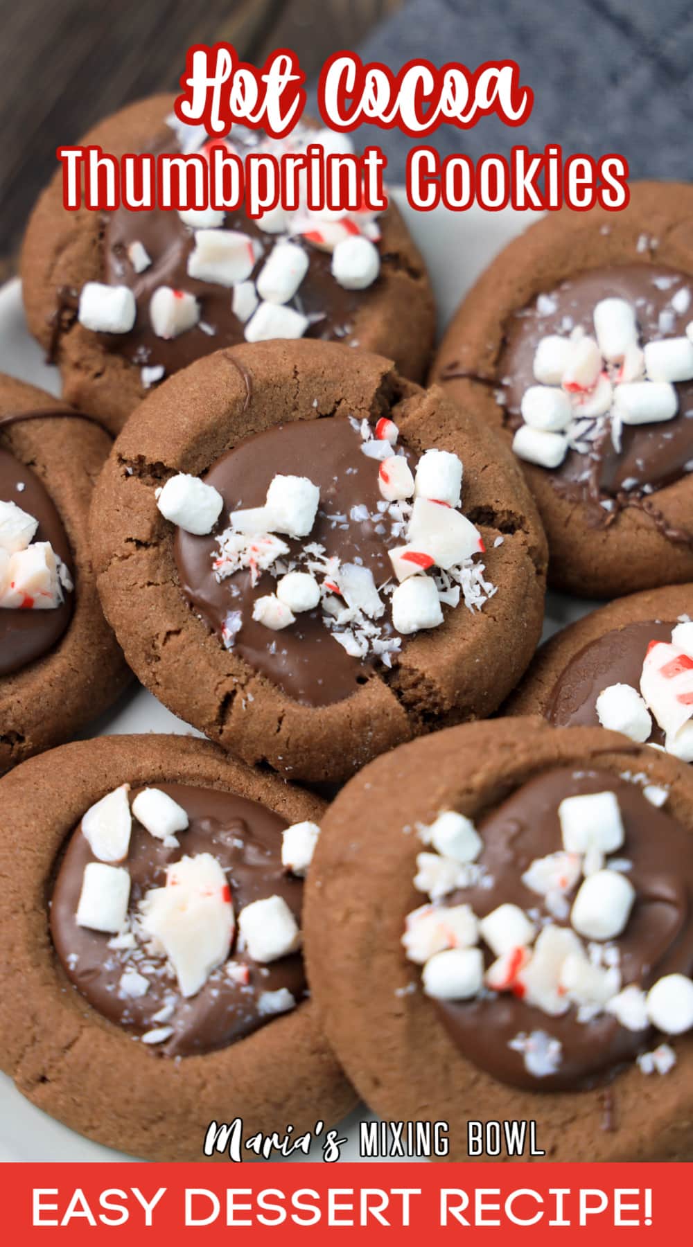 stack of hot cocoa thumbprint cookies on a white plate with the name in text for pinterest