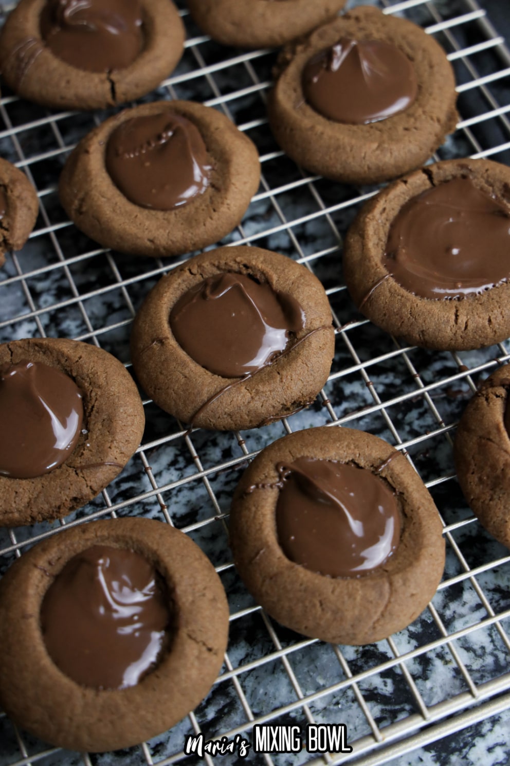 chocolate filled thumbprint cookies on a wire cooling rack