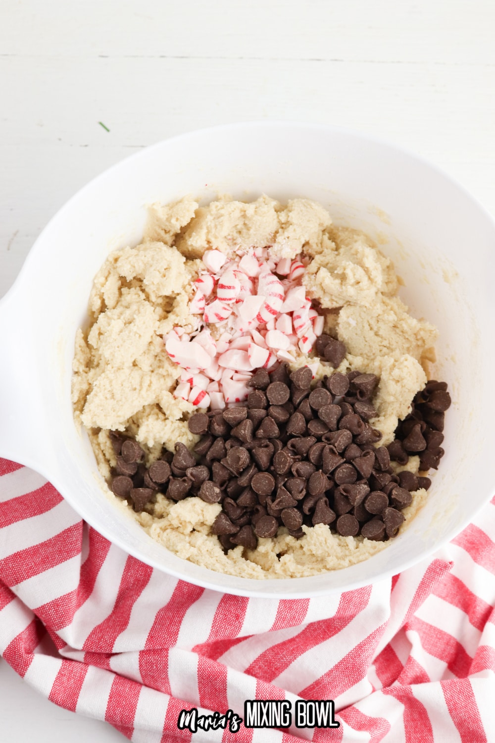 dough with peppermint pieces and chocolate chips being added