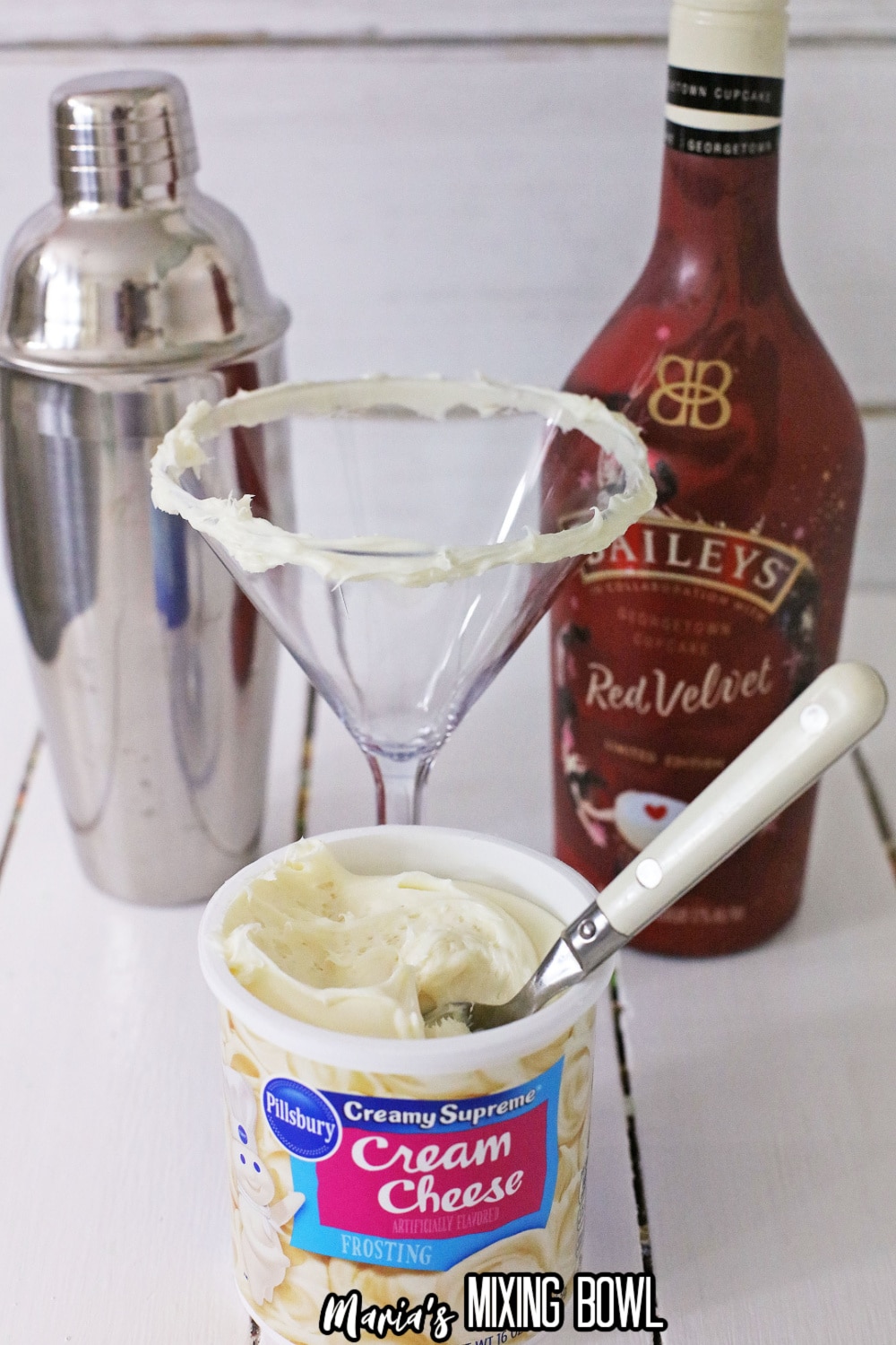cream cheese frosting being spread on top of a cocktail glass