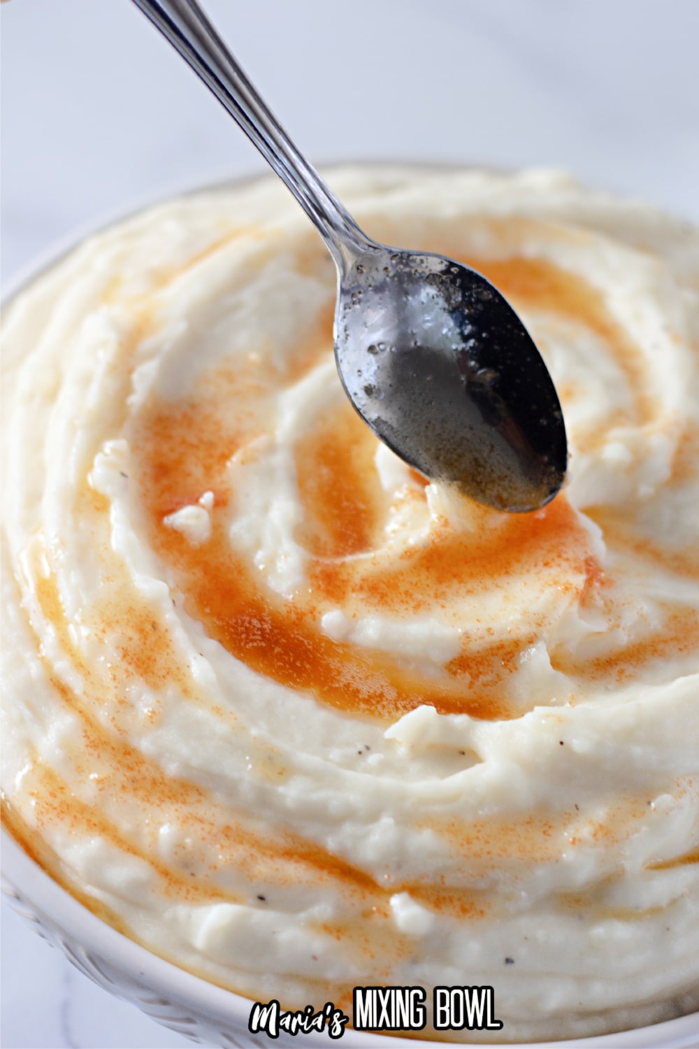 brown butter being spooned on top of mashed potatoes