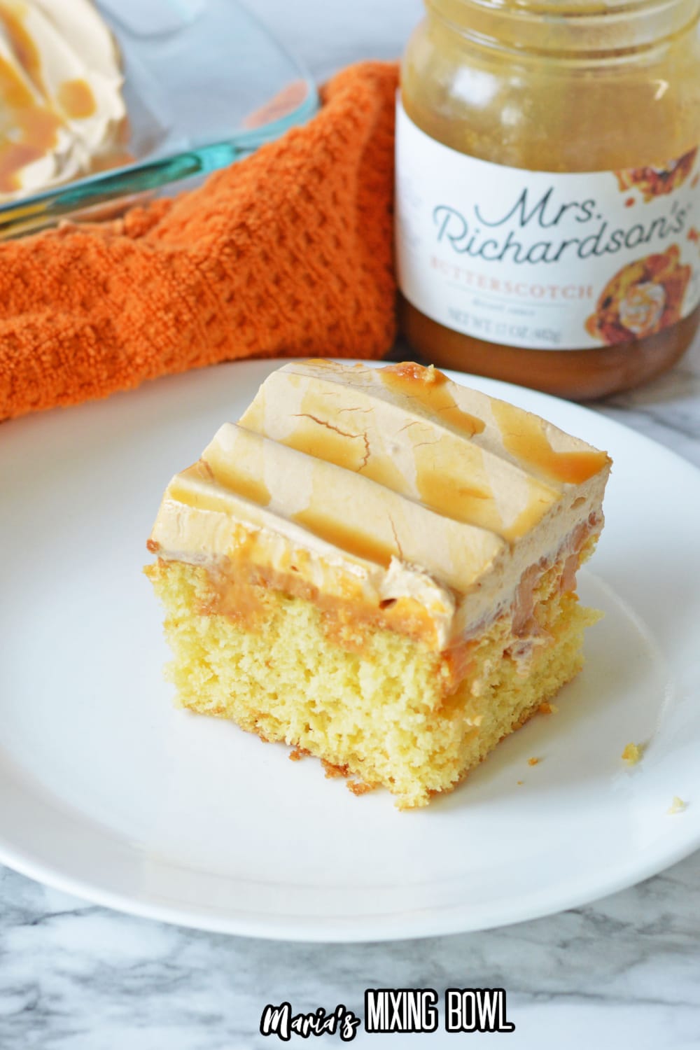 slice of butterscotch poke cake on a white plate