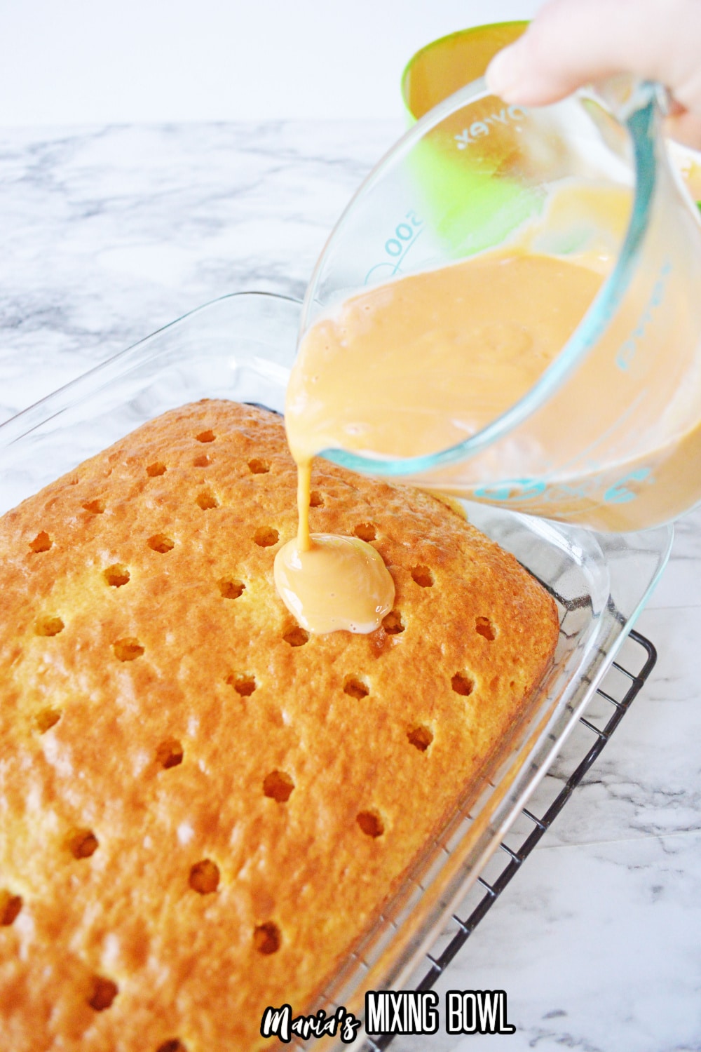 cake with holes poked into it, and pudding being poured over it.