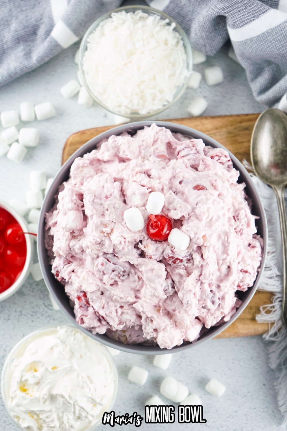 gray bowl filled with cherry fluff and topped with a cherry