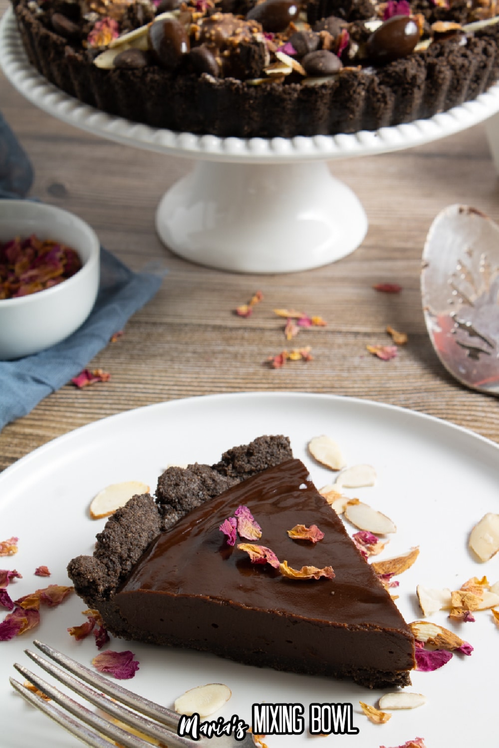 slice of chocolate ganache tart on a white plate