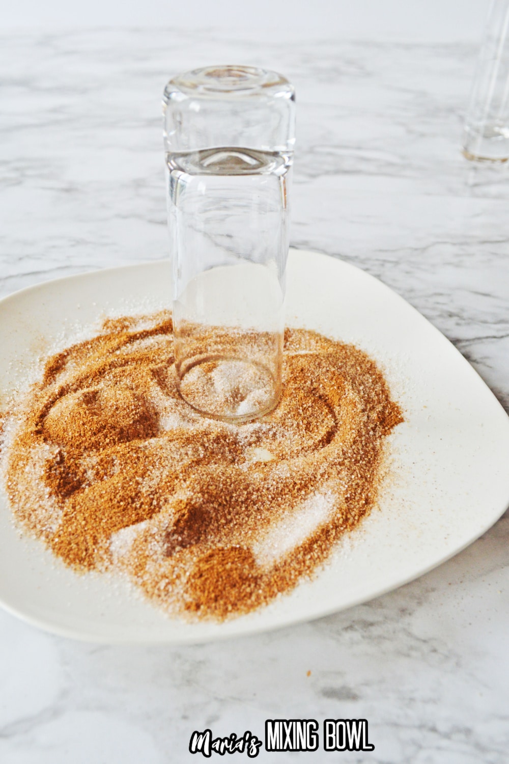 shot glass being rimmed in cinnamon sugar