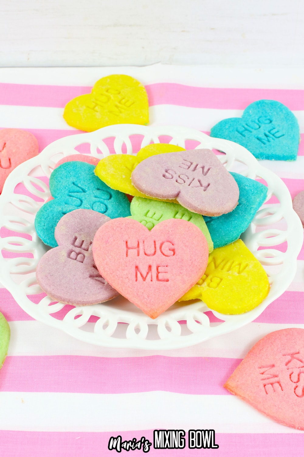 conversation heart cookies stacked on a white plate
