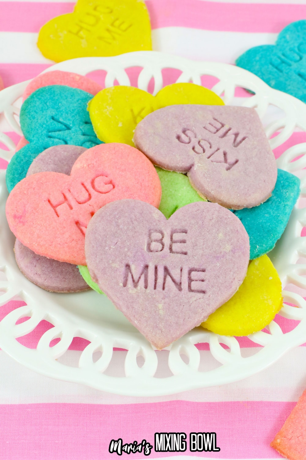 conversation heart cookies stacked on a white plate