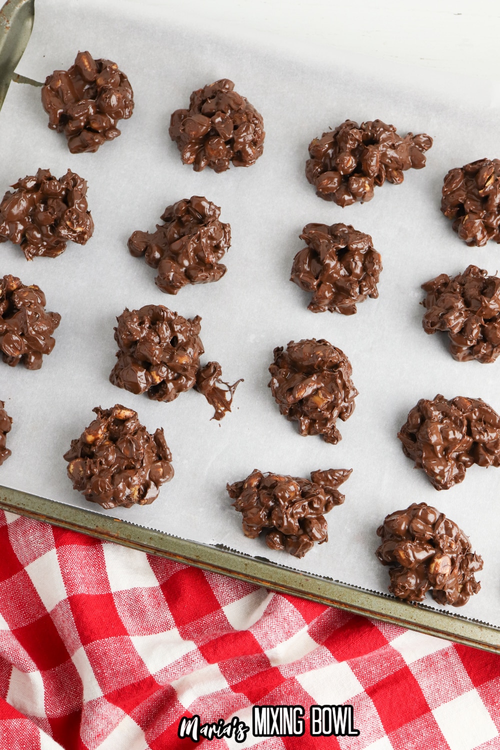 crockpot turtle candy drying on a parchment lined baking sheet