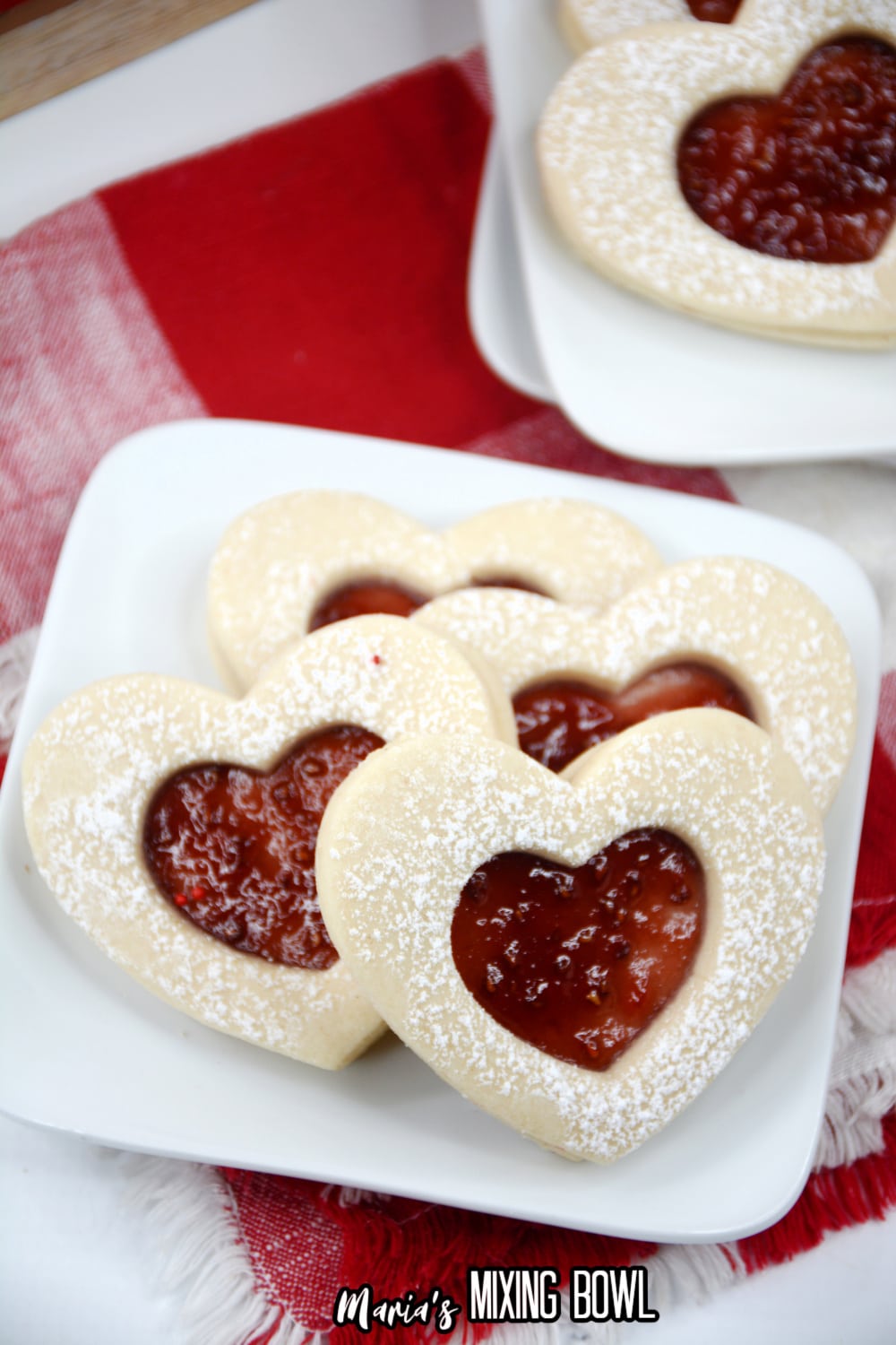 heart shaped jam cookies on a white plate