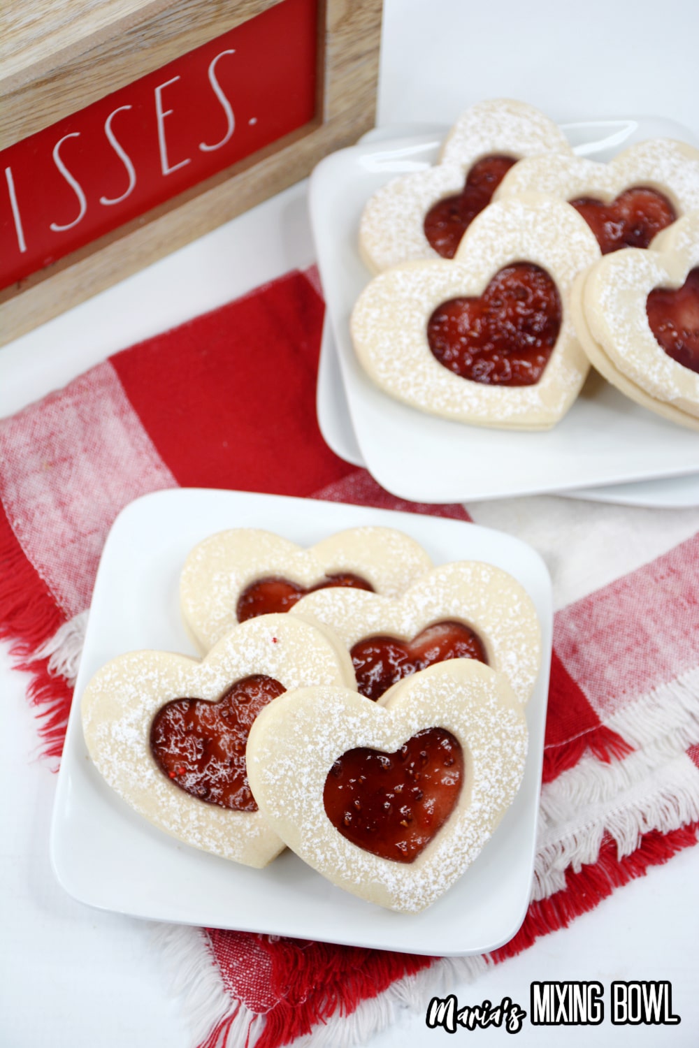 heart shaped jam cookies on a white plate