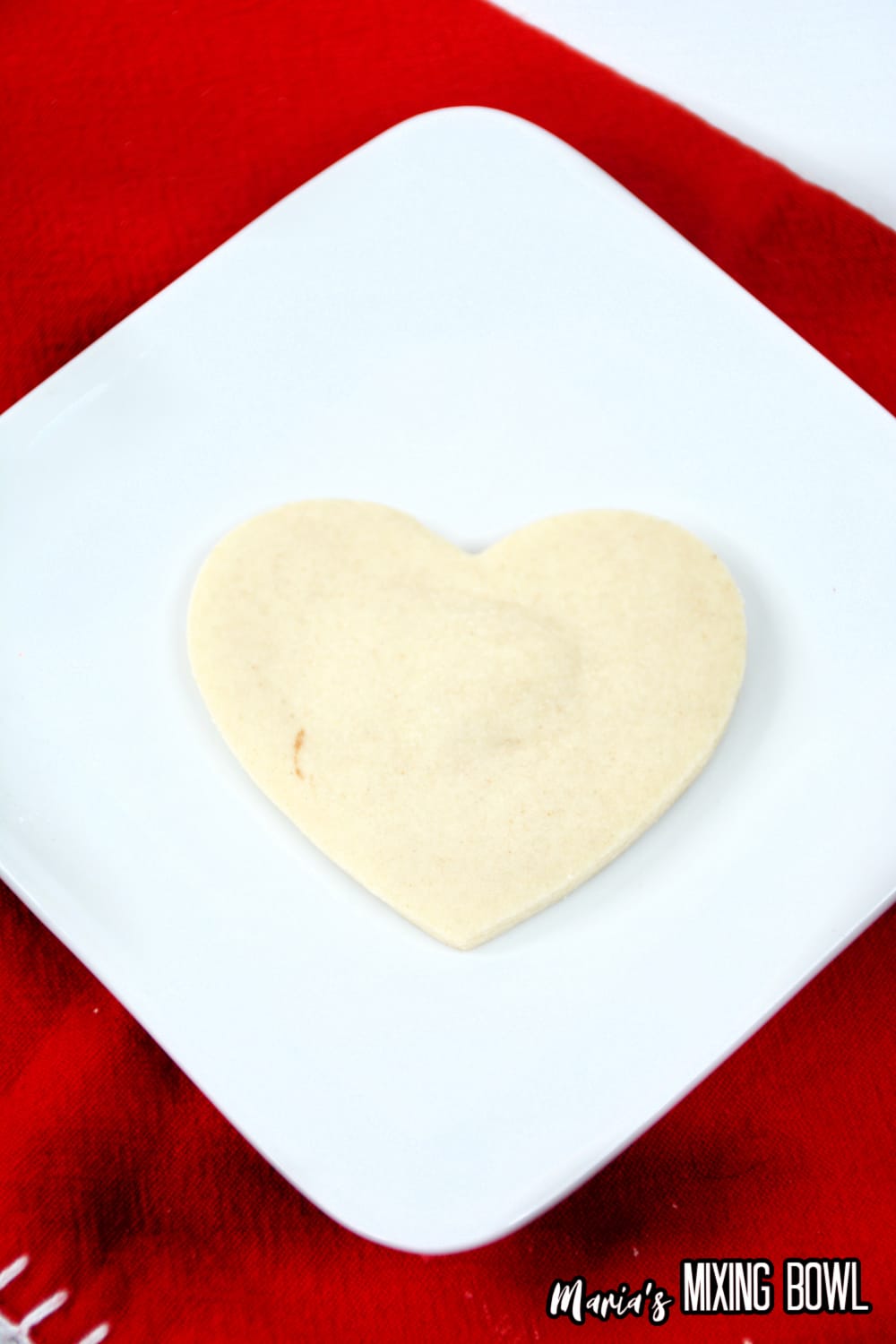 white heart shaped sugar cookie on a white plate