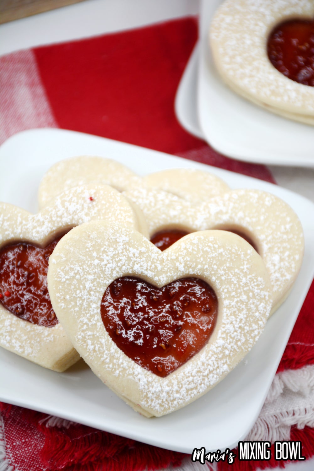 heart shaped jam cookies on a white plate