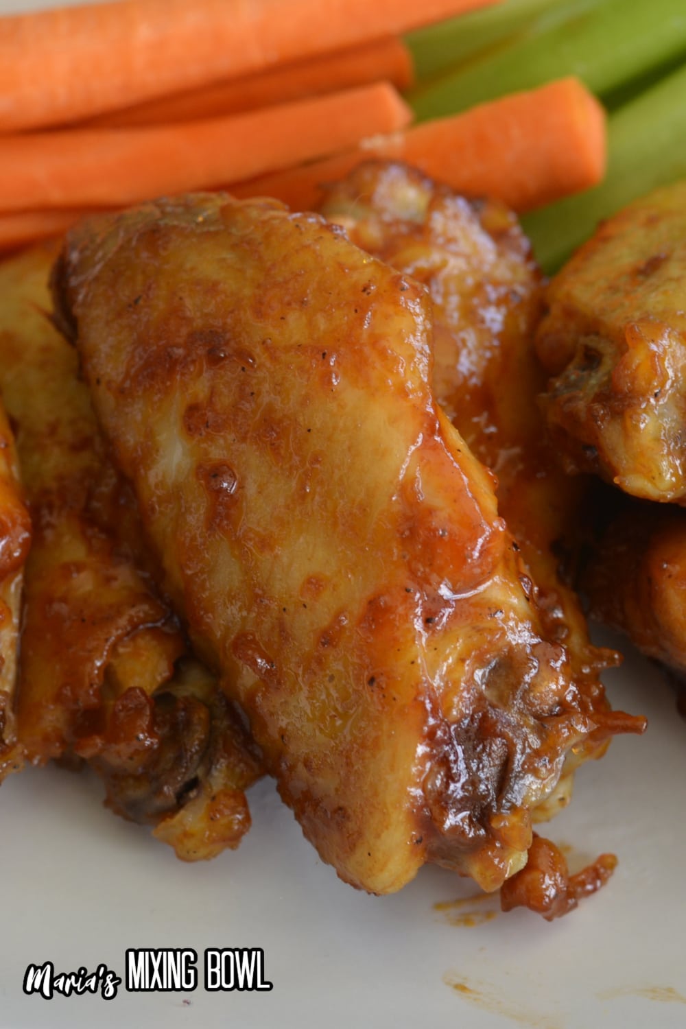 close up of maple bourbon chicken wings on a white plate