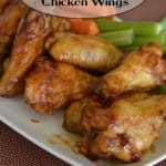 stack of maple bourbon chicken wings on a white plate with the name in text for pinterest
