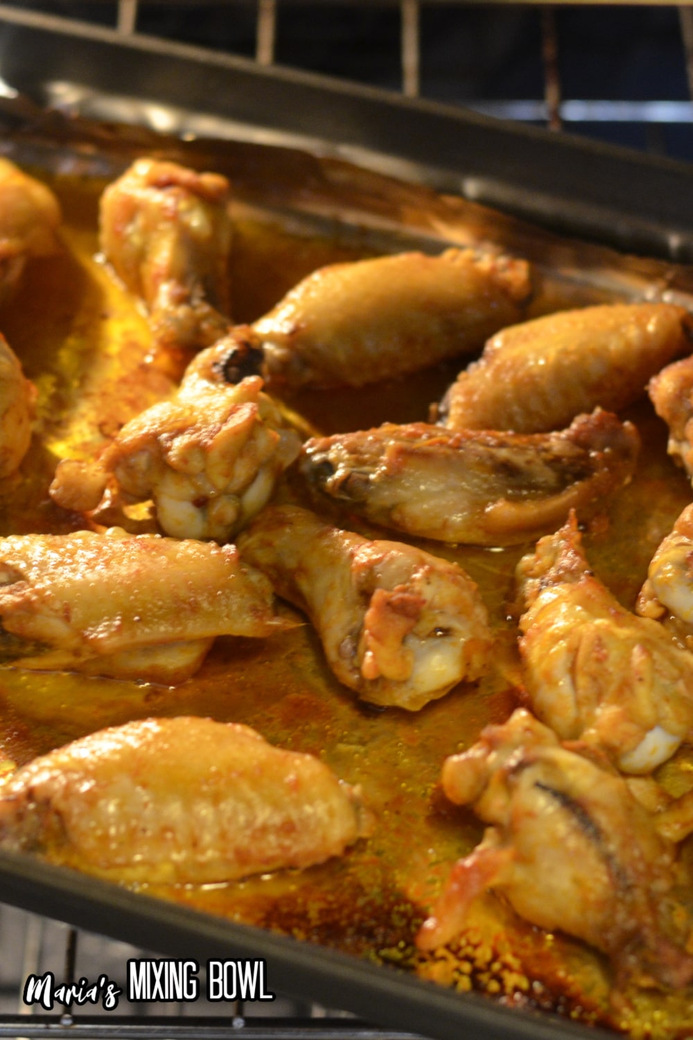 chicken wings roasting on a foil lined baking sheet