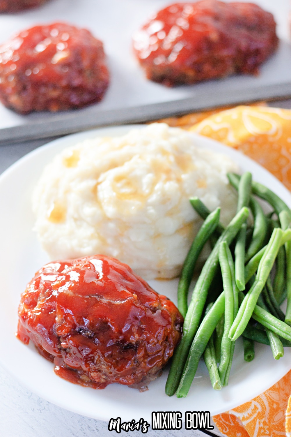 mini meatloaf, mashed potatoes, and green beans on a white plate