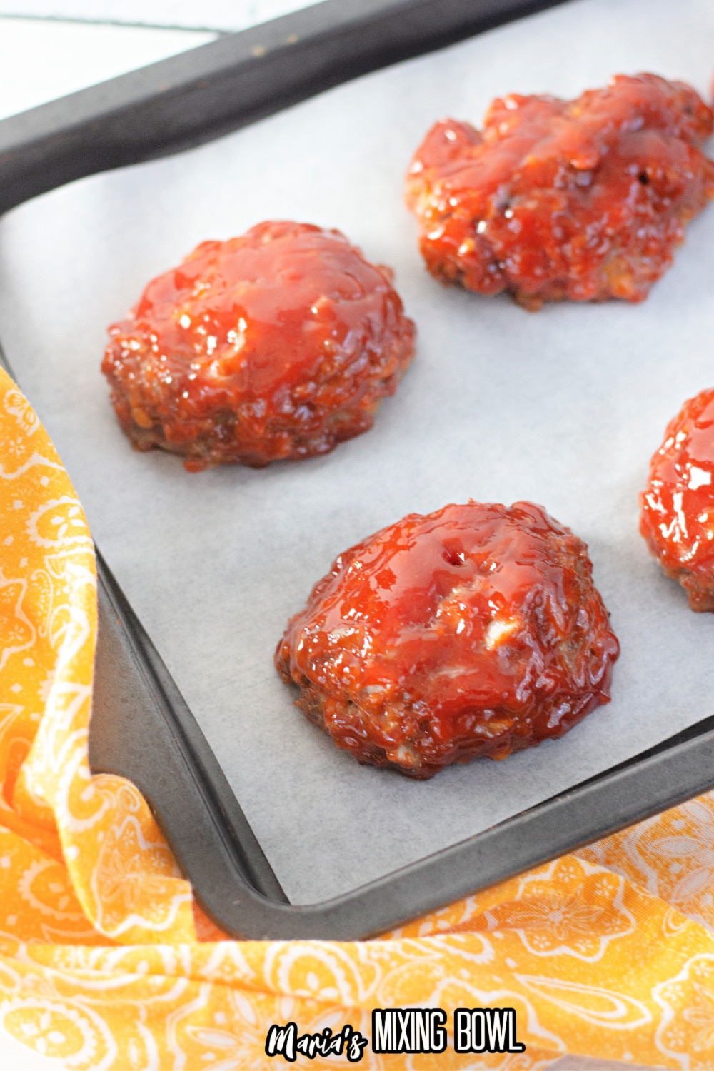 mini meatloaves on a parchment lined baking sheet
