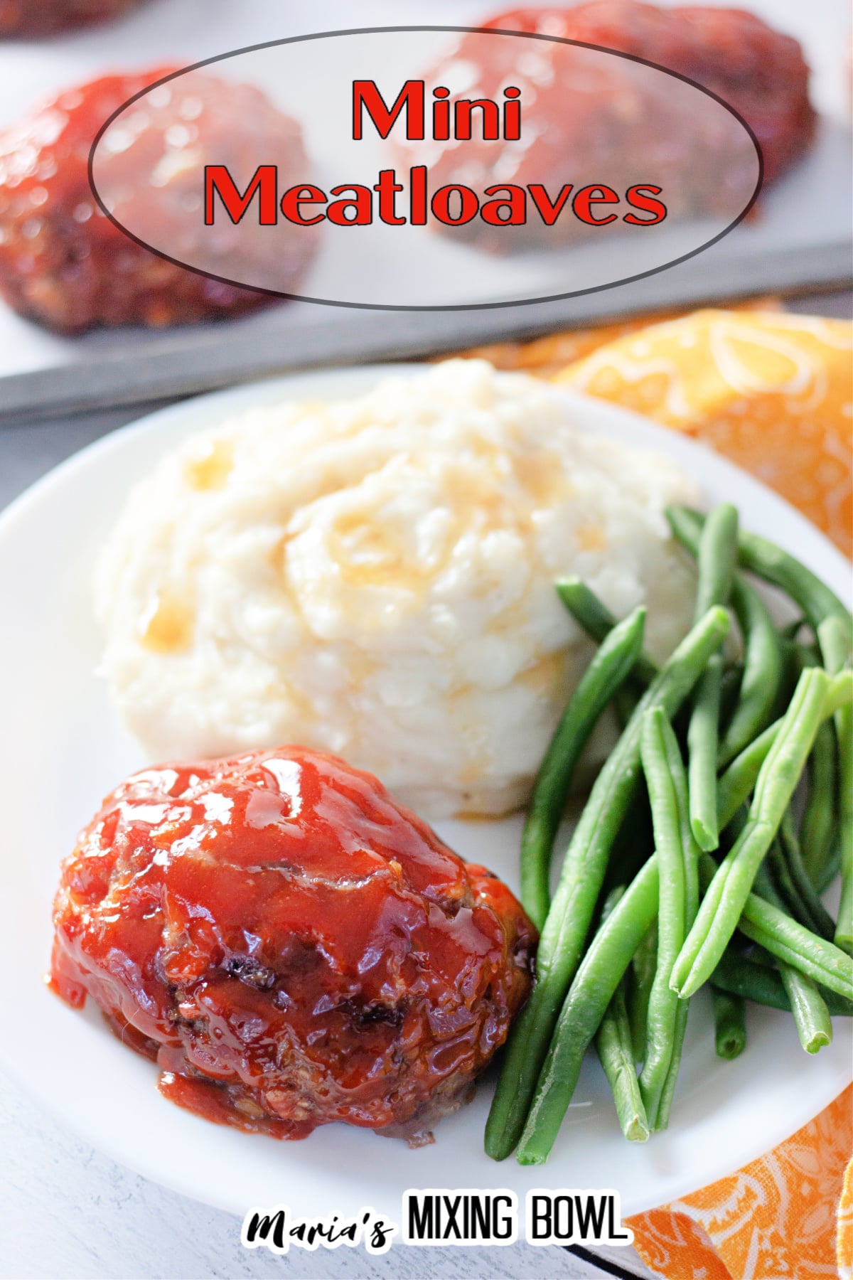 mini meatloaf, mashed potatoes, and green beans on a white plate with the name in text for pinterest