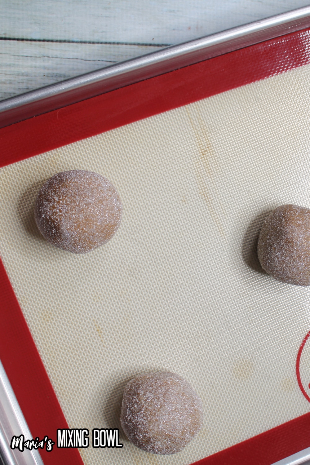 cookie dough balls on a silicone lined baking sheet
