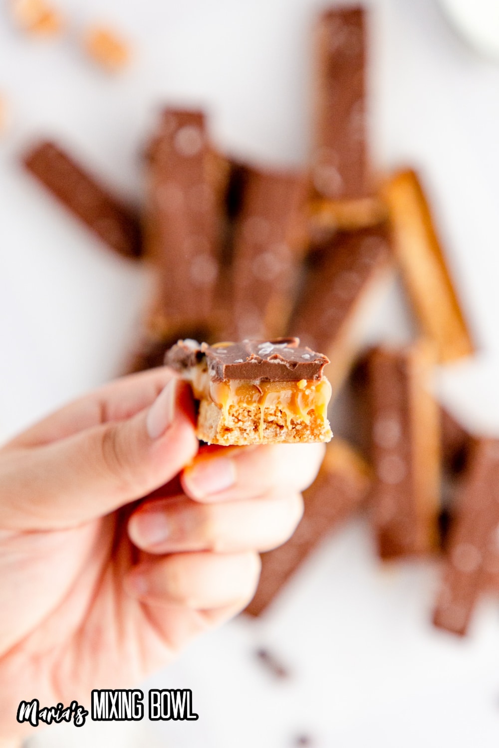 salted caramel chocolate bar being held in a woman's fingers