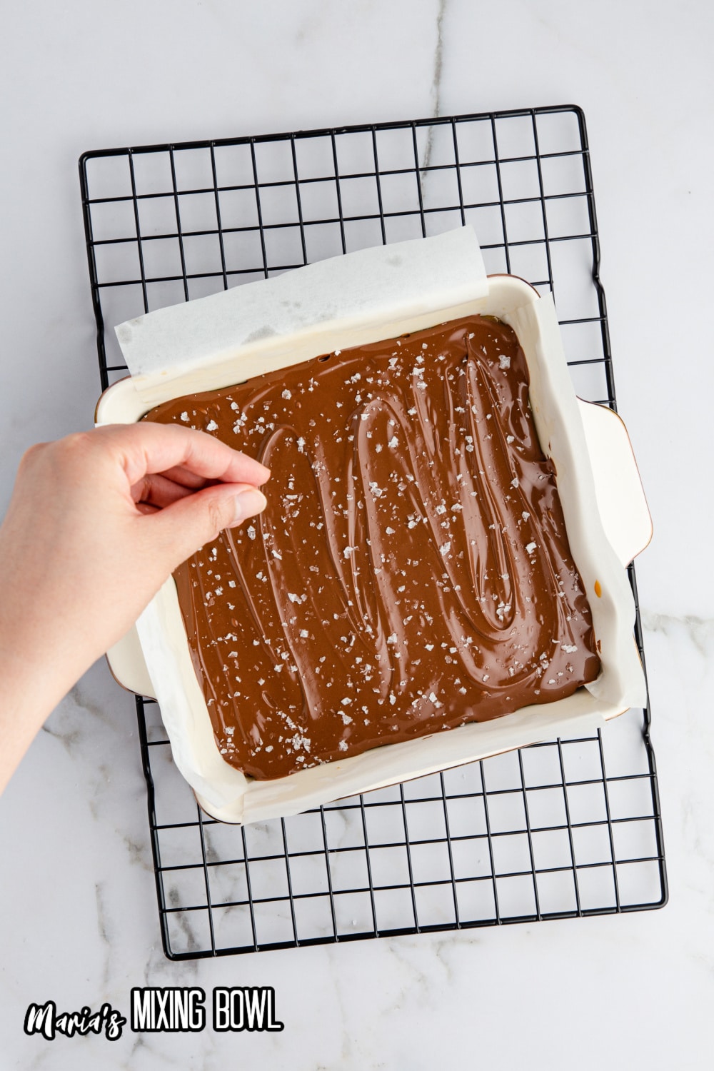 salt flakes being sprinkled on top of chocolate