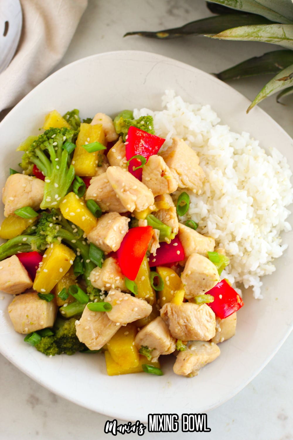 pineapple chicken on a plate next to the rice
