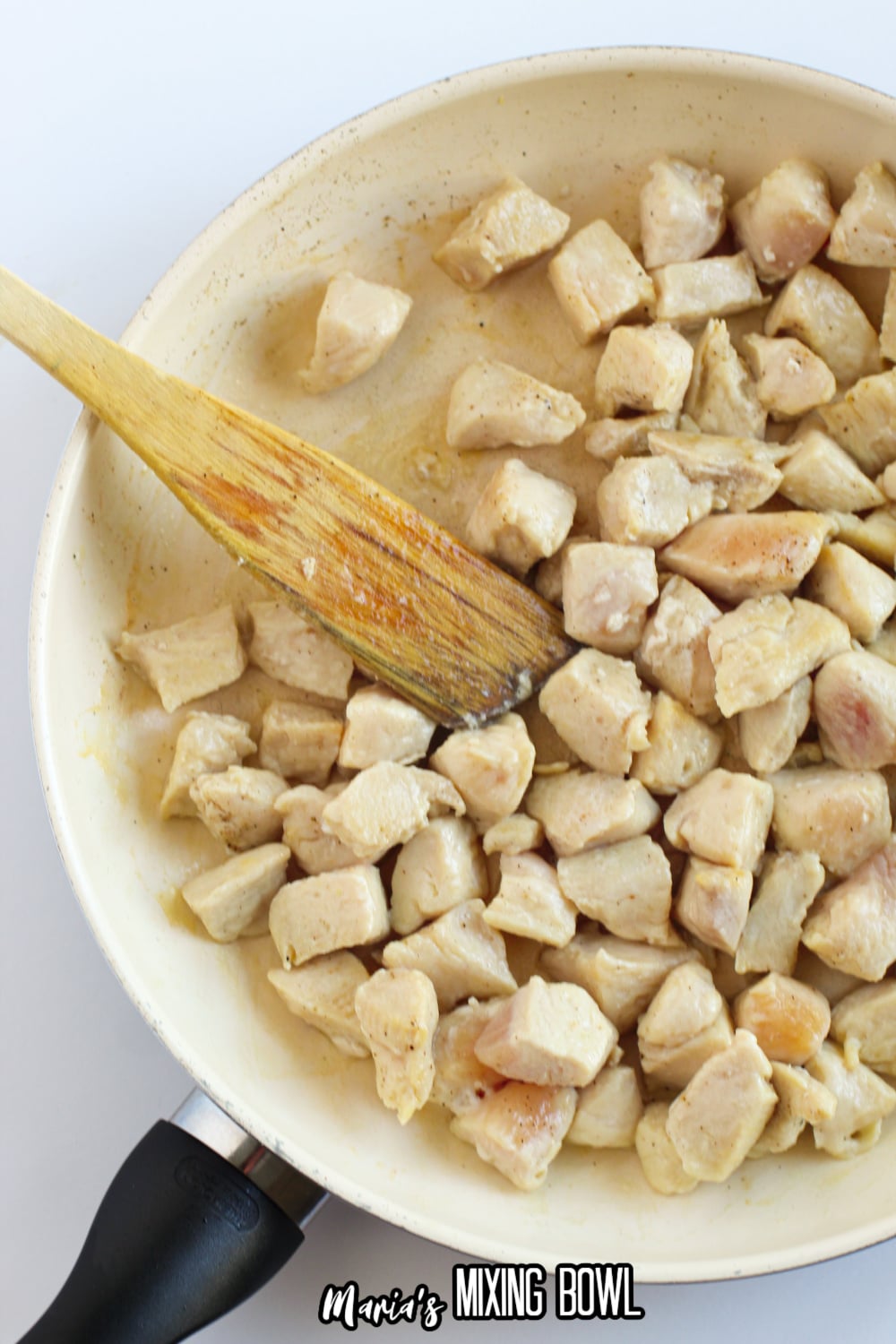 cubed chicken being browned in a skillet