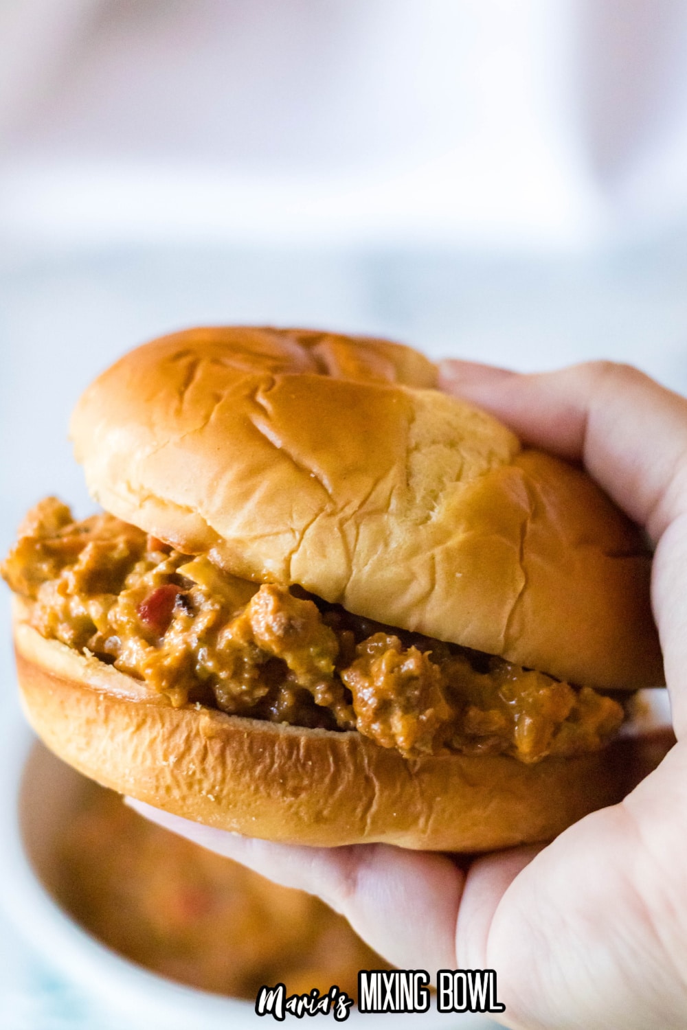 slow cooker mexican sloppy joe sandwich held in a womens hand