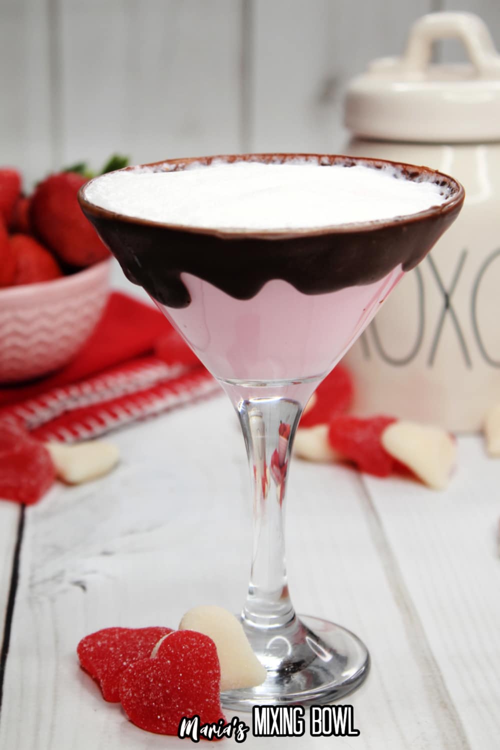 glass of strawberries and cream martini with a bowl of strawberries in the background
