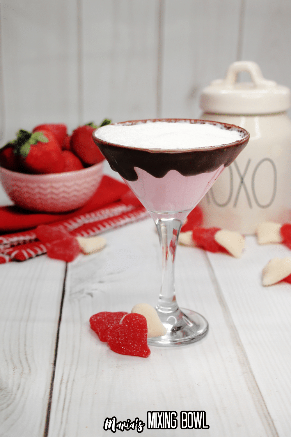 glass of strawberries and cream martini with a bowl of strawberries in the background