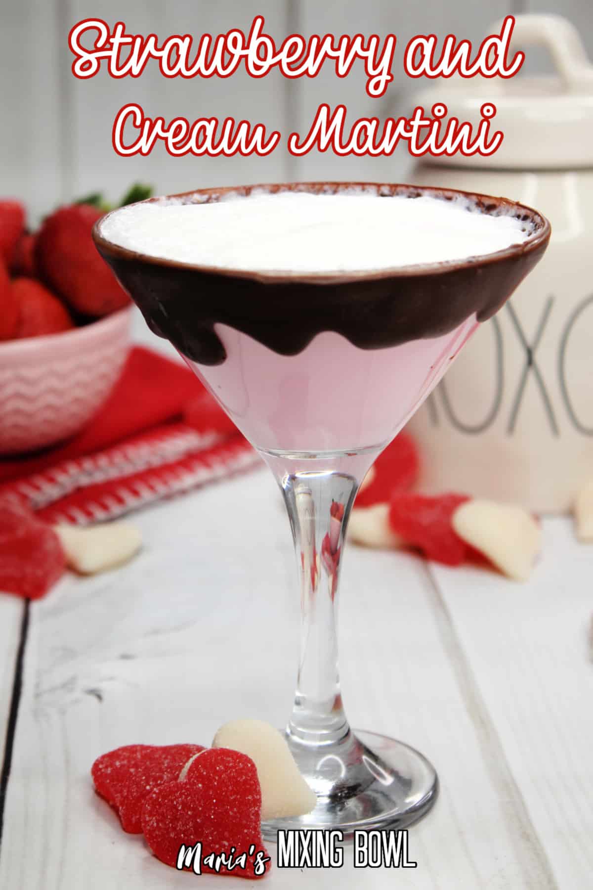 glass of strawberries and cream martini with a bowl of strawberries in the background