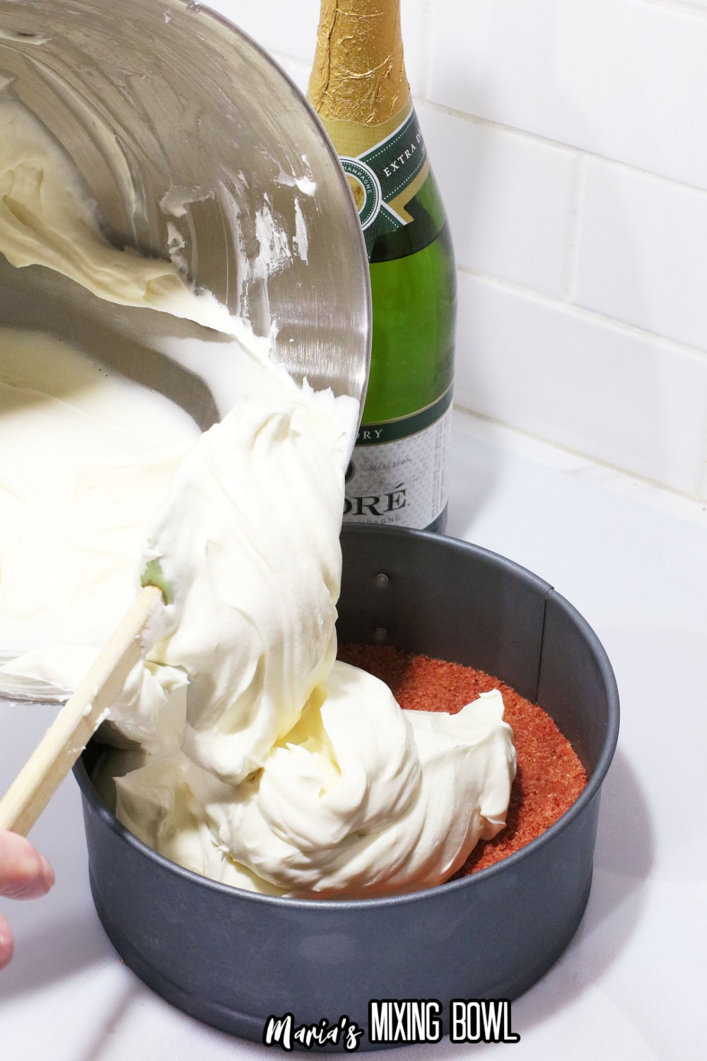 cream cheese mixture being poured on top of crust in a springform pan
