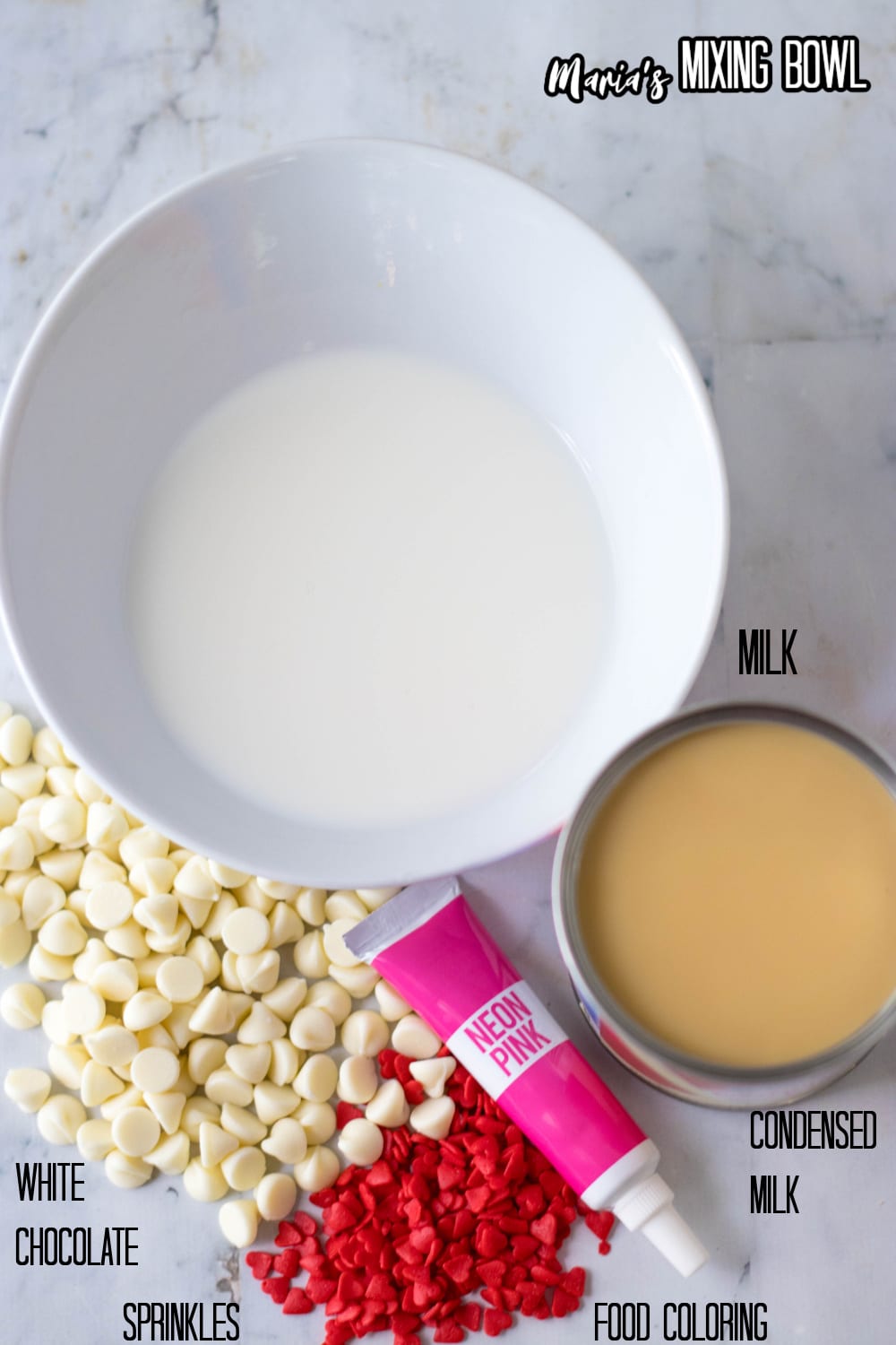 bowl of milk, white chocolate, sprinkles, condensed milk, and pink food coloring on a marble background