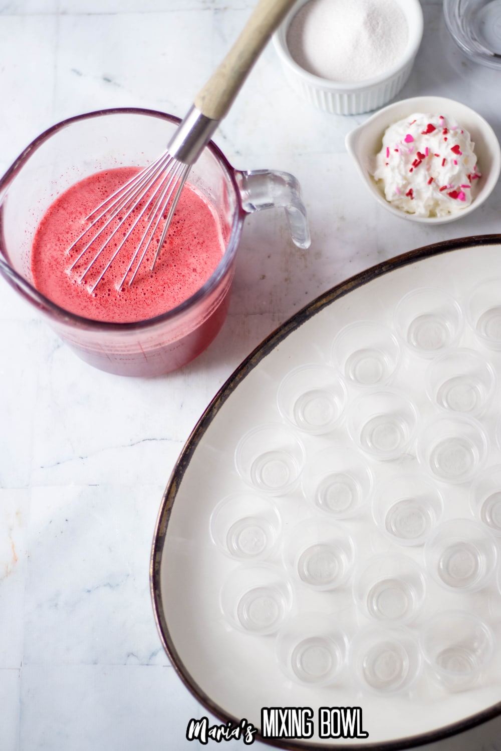 jello being mixed in a glass measuring cup
