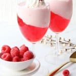 valentine's day parfait in a wine glass topped with a raspberry
