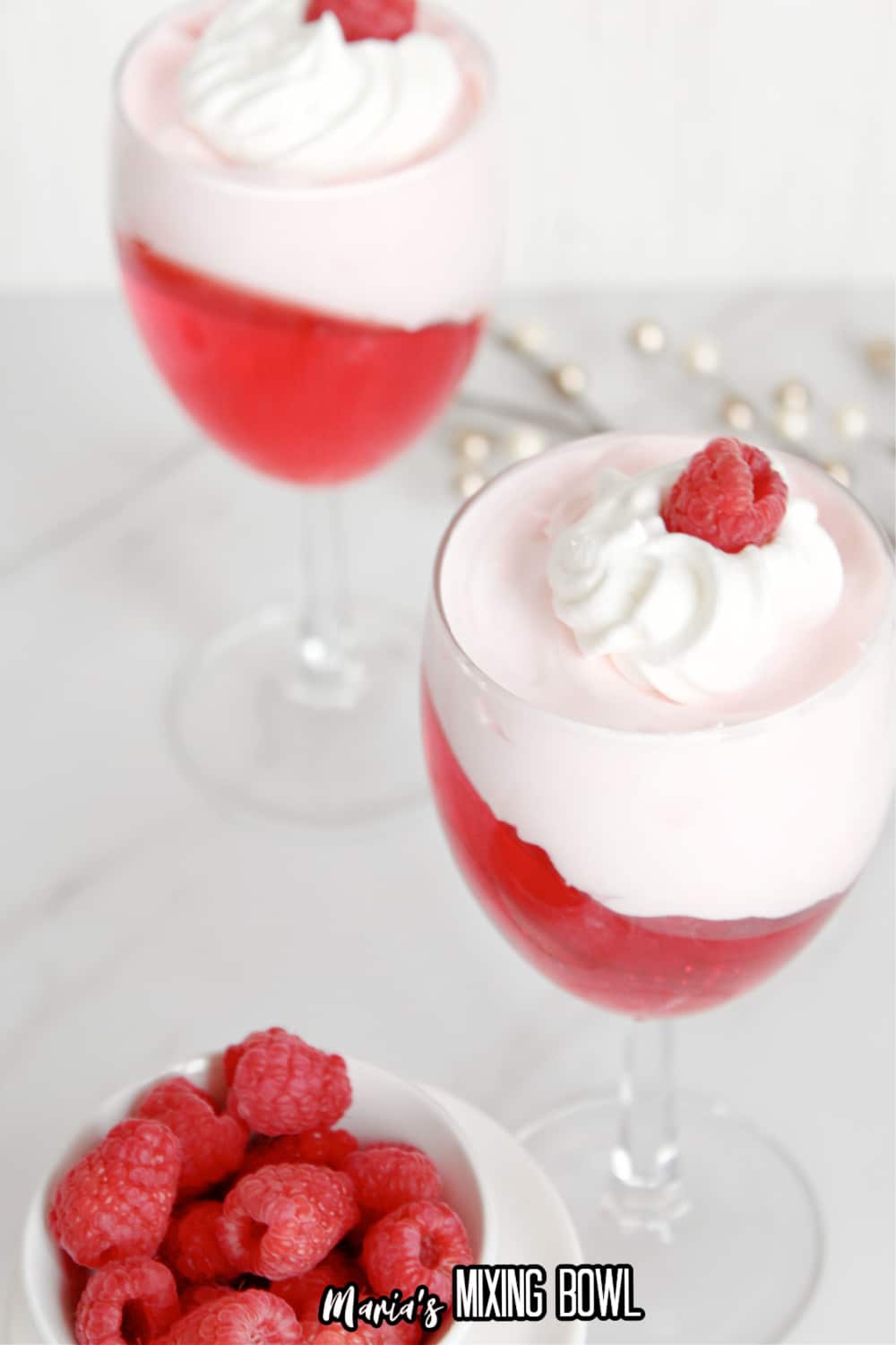 valentine's day parfait in a wine glass topped with a raspberry