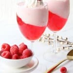 valentine's day parfait in a wine glass topped with a raspberry with the name in text for pinterest