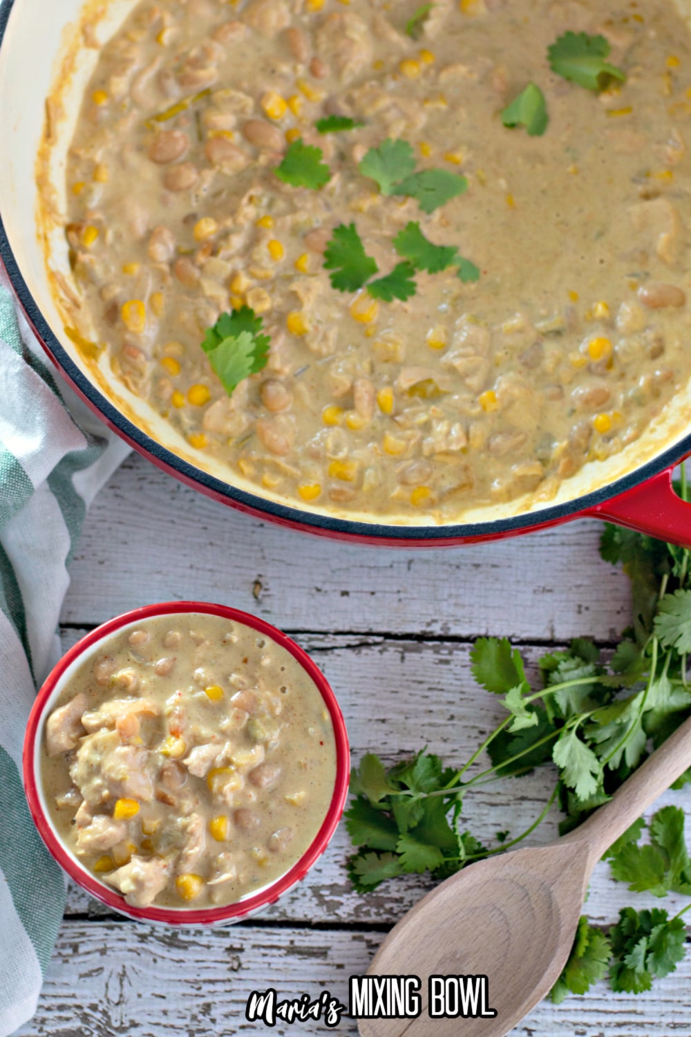 small bowl of white chicken chili with a dutch oven full of the soup in the background