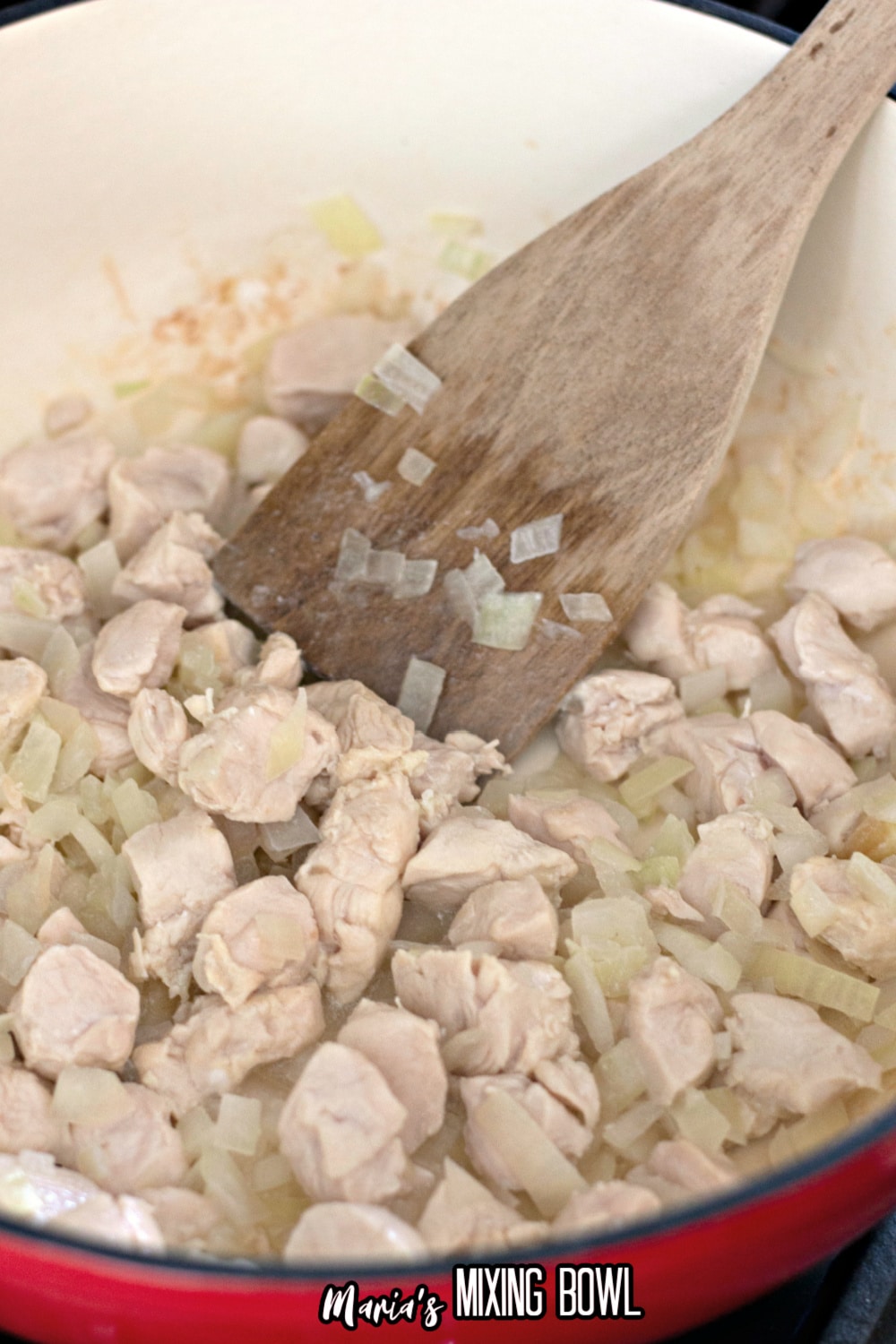 chicken and onions being browned in a dutch oven