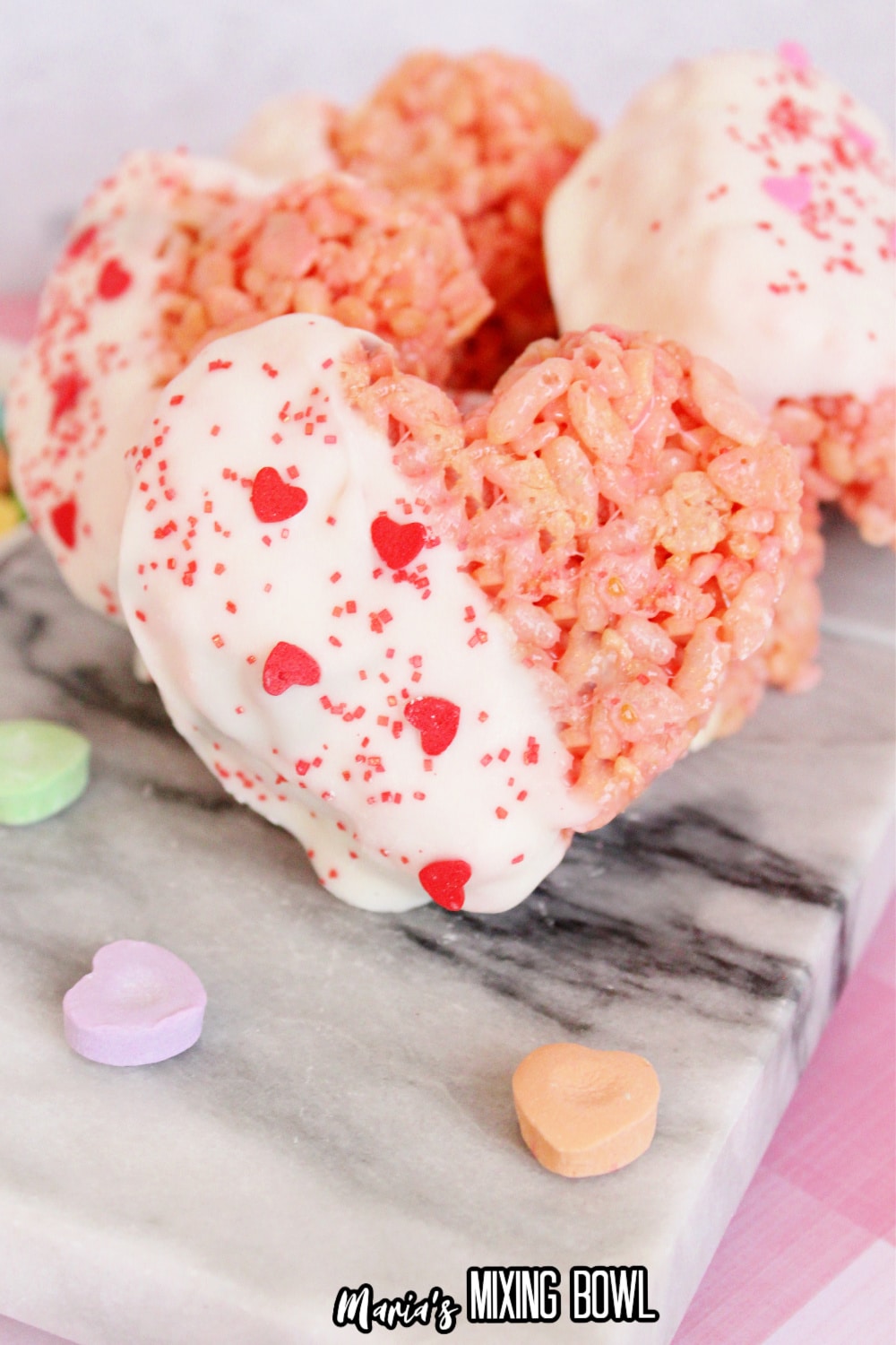 white chocolate dipped rice krispie treat on a pink and white tablecloth