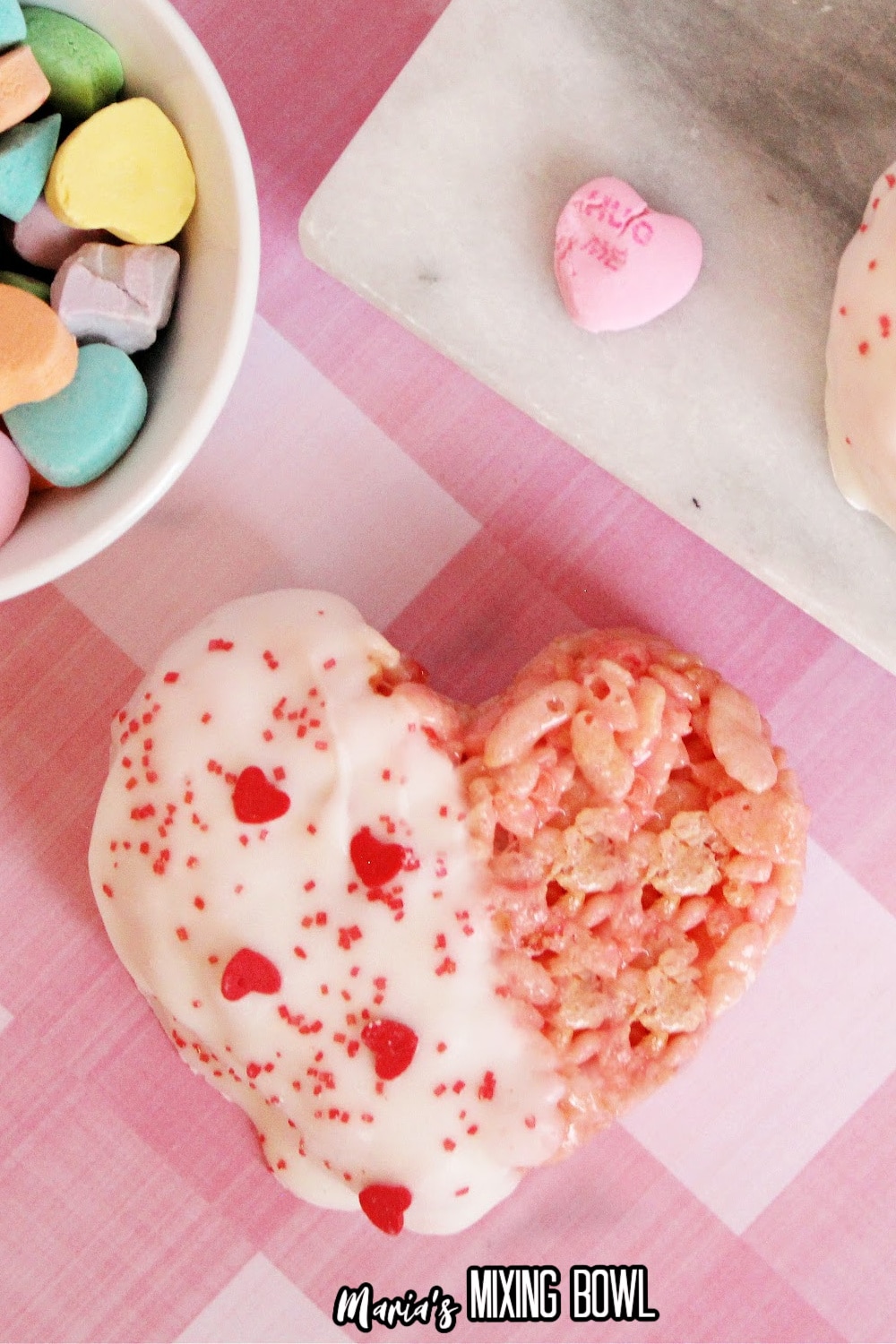 white chocolate dipped rice krispie treat on a pink and white tablecloth