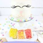 slice of bunny cake on a white plate with a full cake on a cake stand with the name in text for pinterest