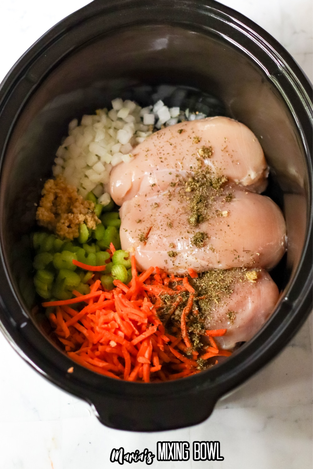 chicken breasts, seasonings and vegetables in a crock pot liner