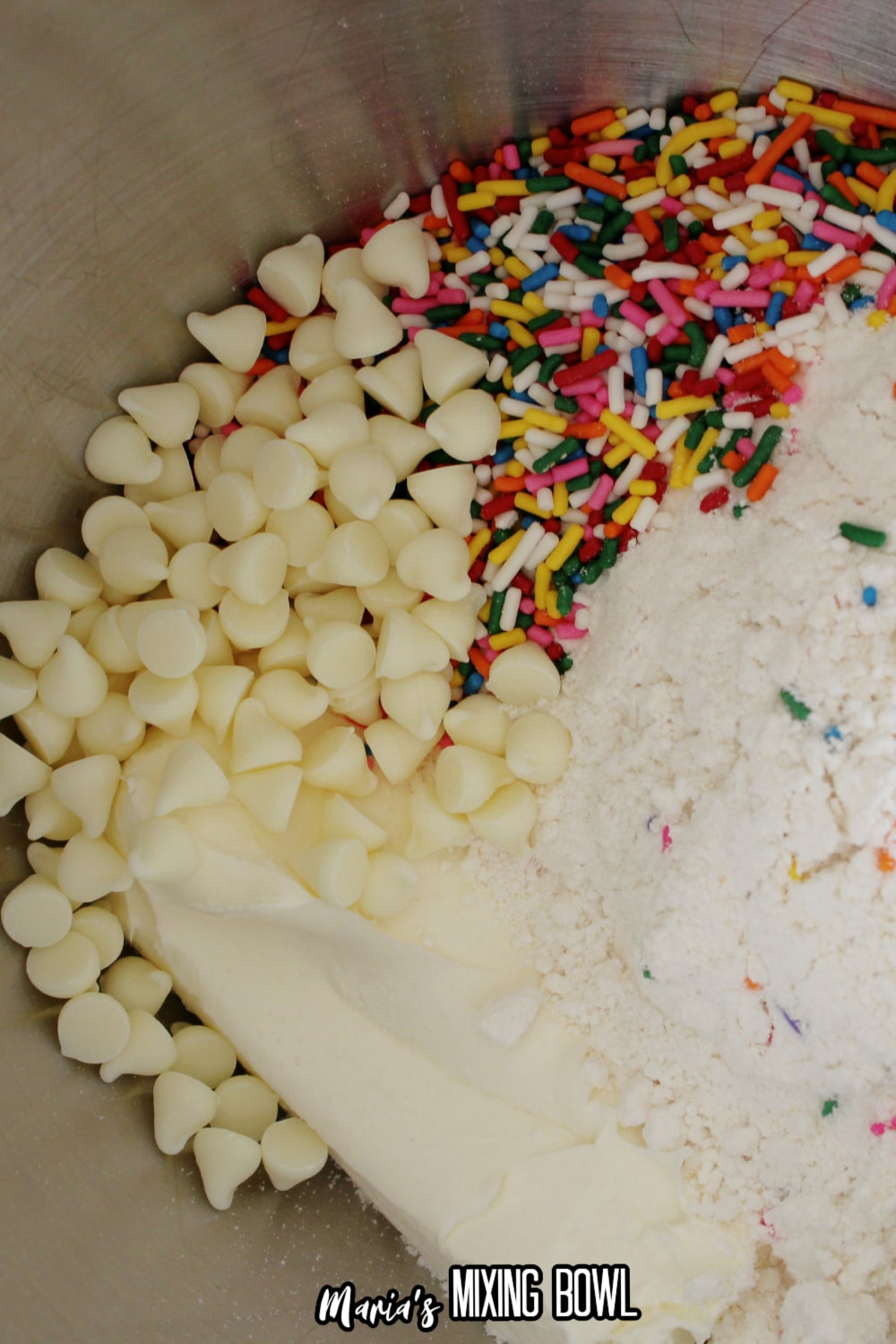 chocolate chips, sprinkles, cake mix, and cream cheese being mixed together