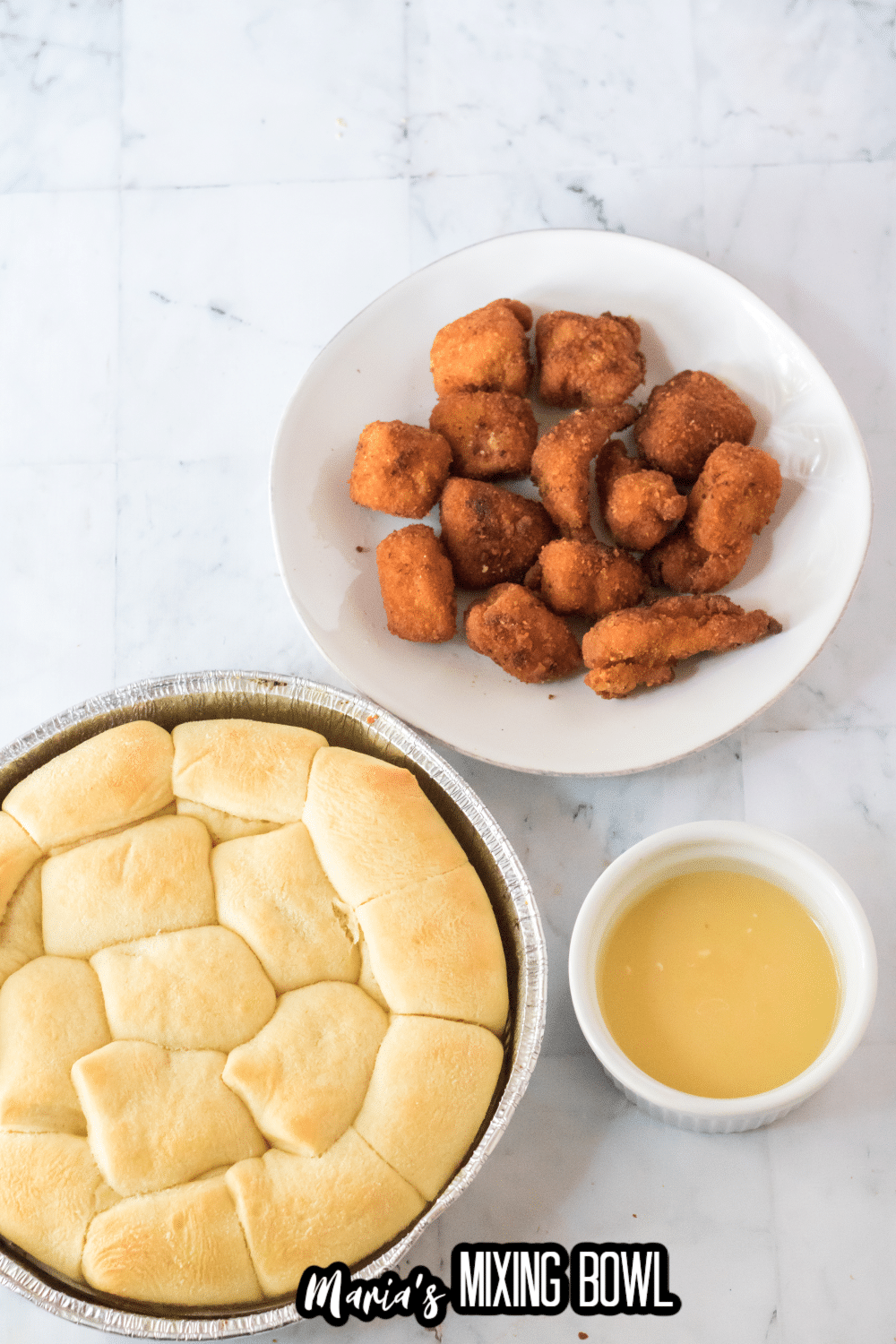a plate of nuggets and a baking sheet filled with rolls